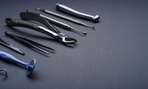 dental-instruments-composed-gray-background-with-copy-space-min